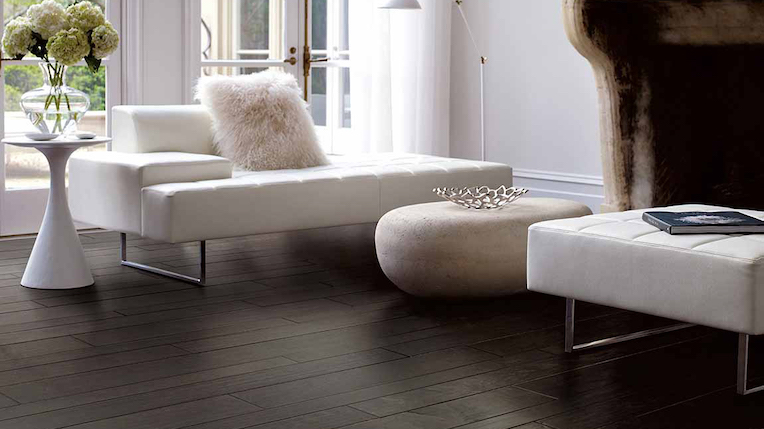 dark hardwood flooring planks in an elegant living room with white couch and fireplace