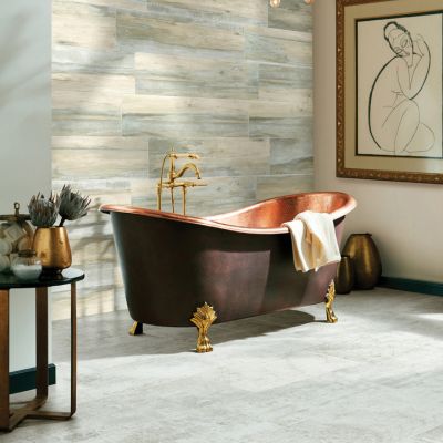 grey tile flooring and wood look tile accent wall in a stylish Columbia bathroom with copper tub